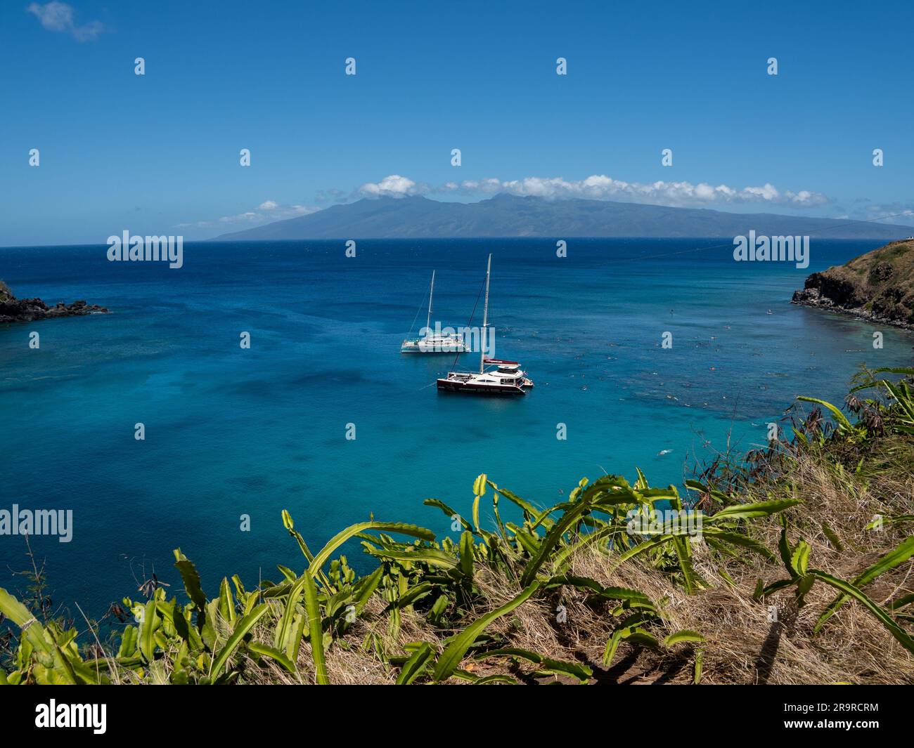 Boats are anchored in a shallow cove that is perfect for snorkeling Stock Photo