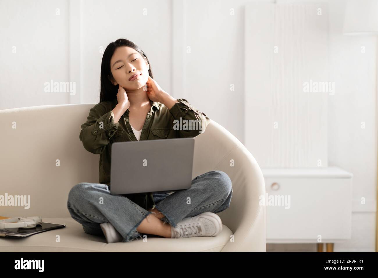Tired young asian woman independent contractor massaging her neck Stock ...