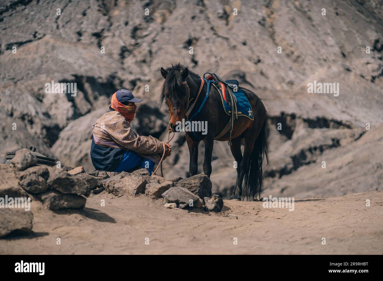 Close up shot of unrecognized tenggerese horseman waiting for tourists. Horse trip in Bromo Mount volcano Stock Photo