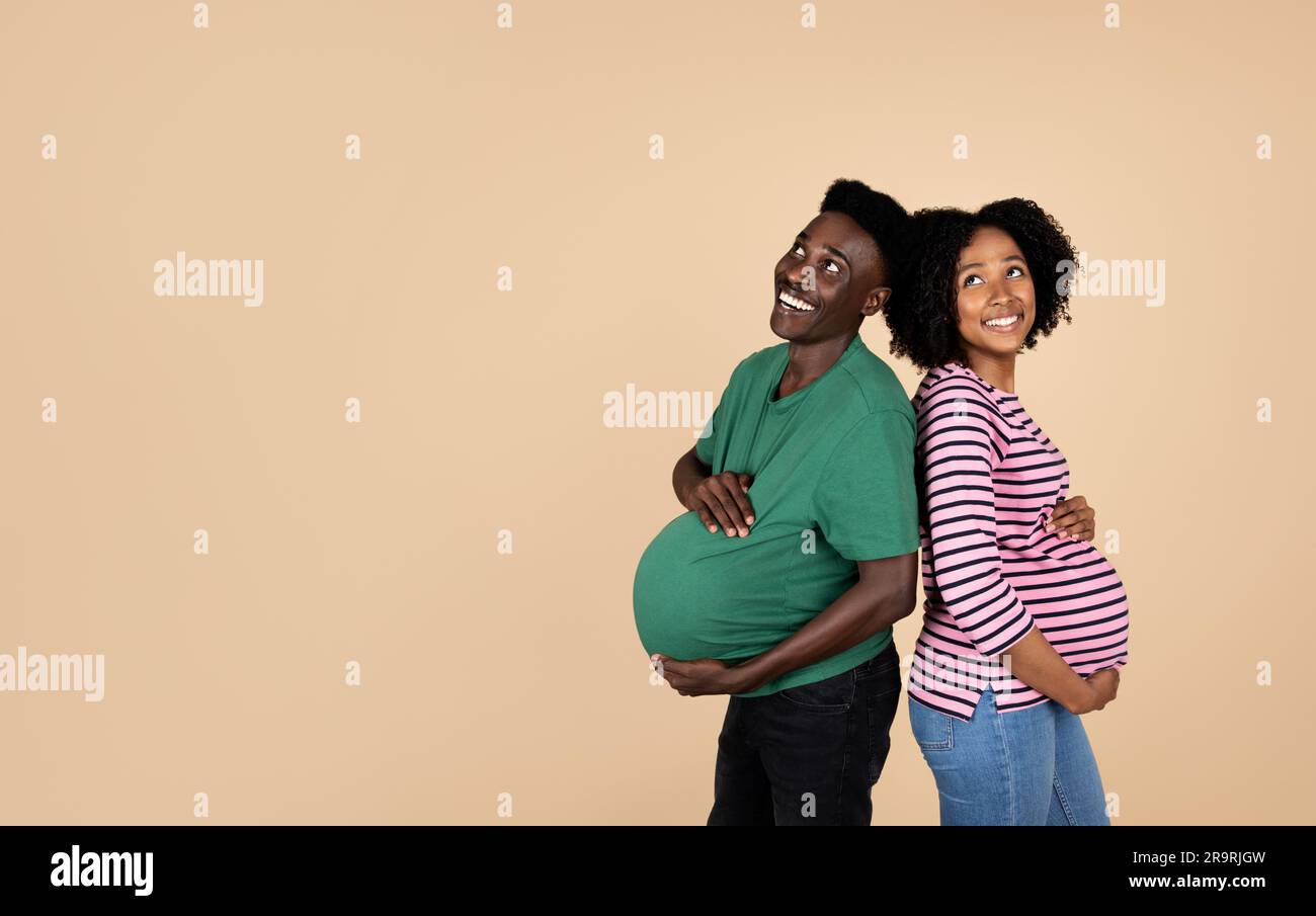 Happy young african american husband and pregnant wife with big belly ...