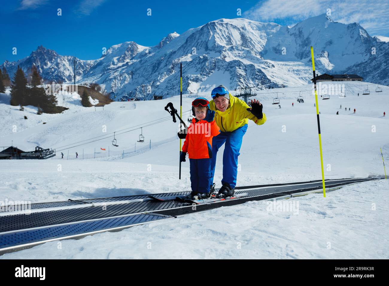 Little 3 years old boy and father on magic carpet at ski resort Stock Photo