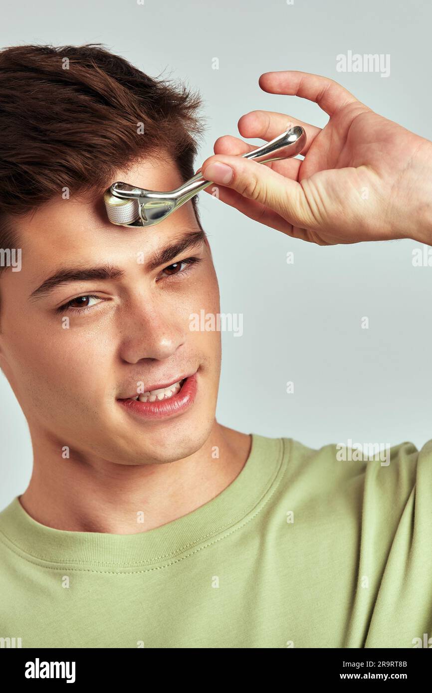 A young handsome guy with brown hair doing self-care routine using a ...