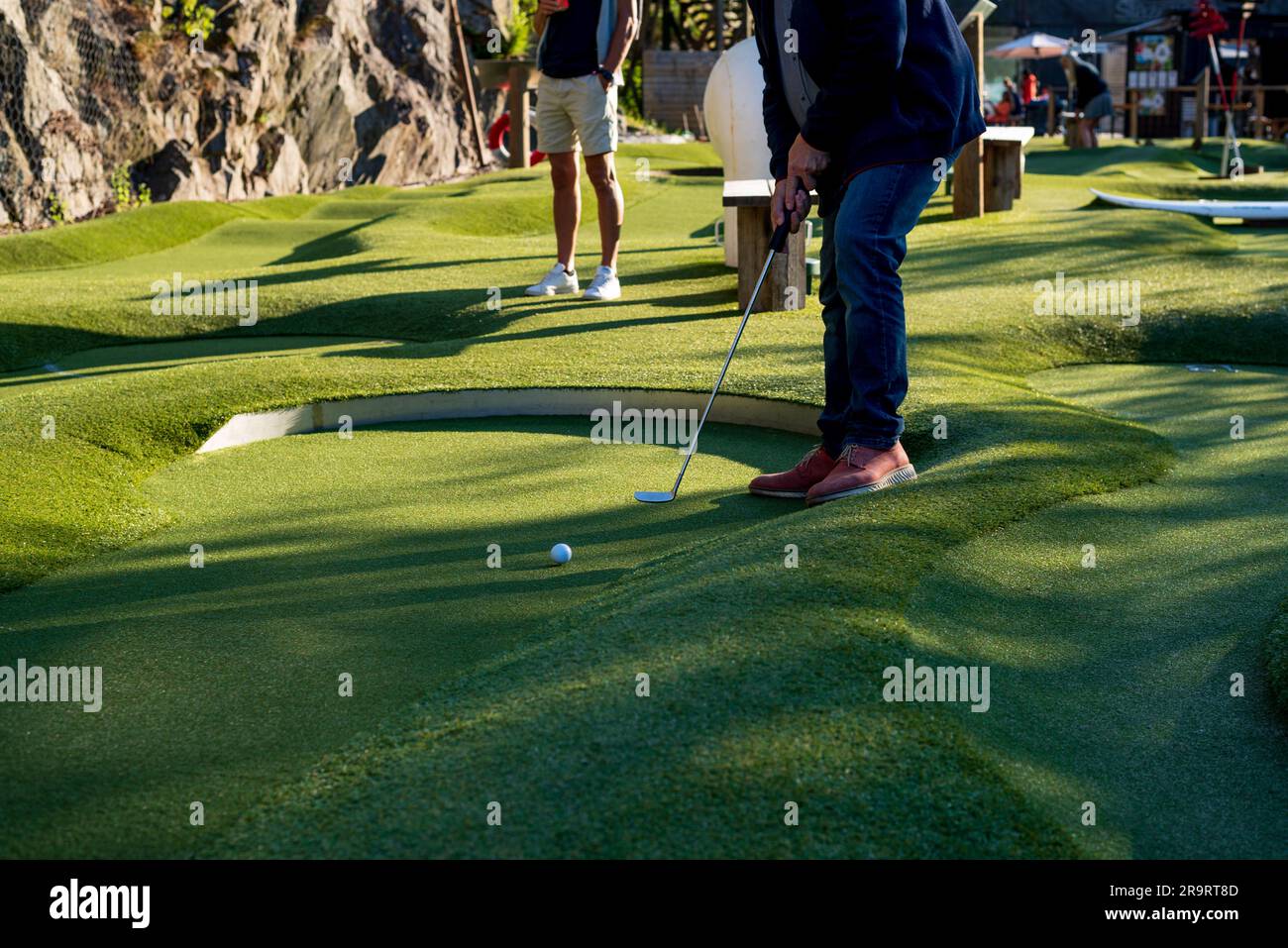 photo of man in brown shoes is playing golf on lawn Stock Photo