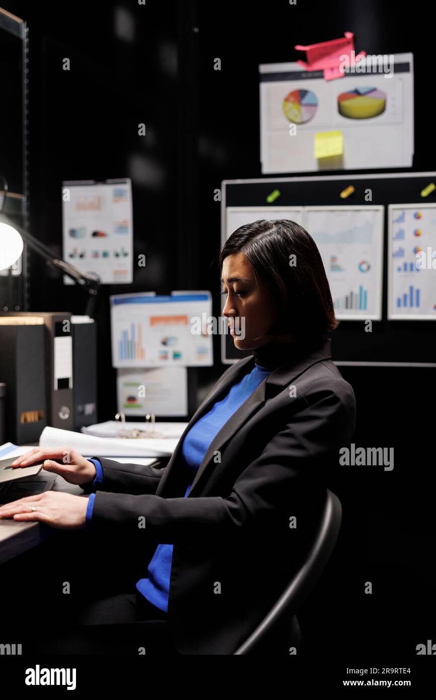 Tired accountancy asian employee in storage room office clocking out