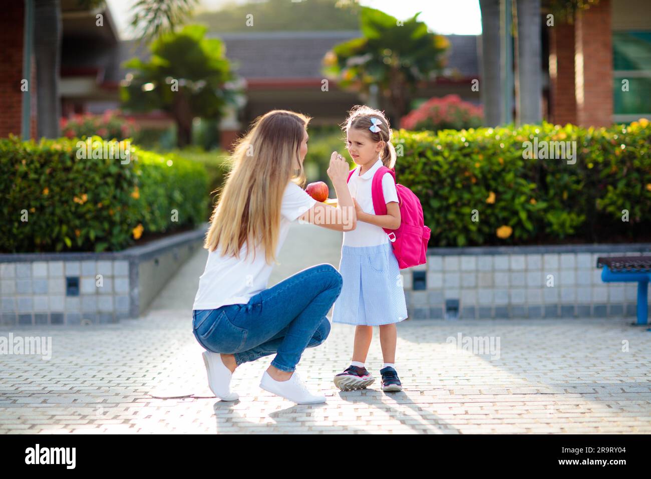 Mother and kids after school. Young mom picking up children after