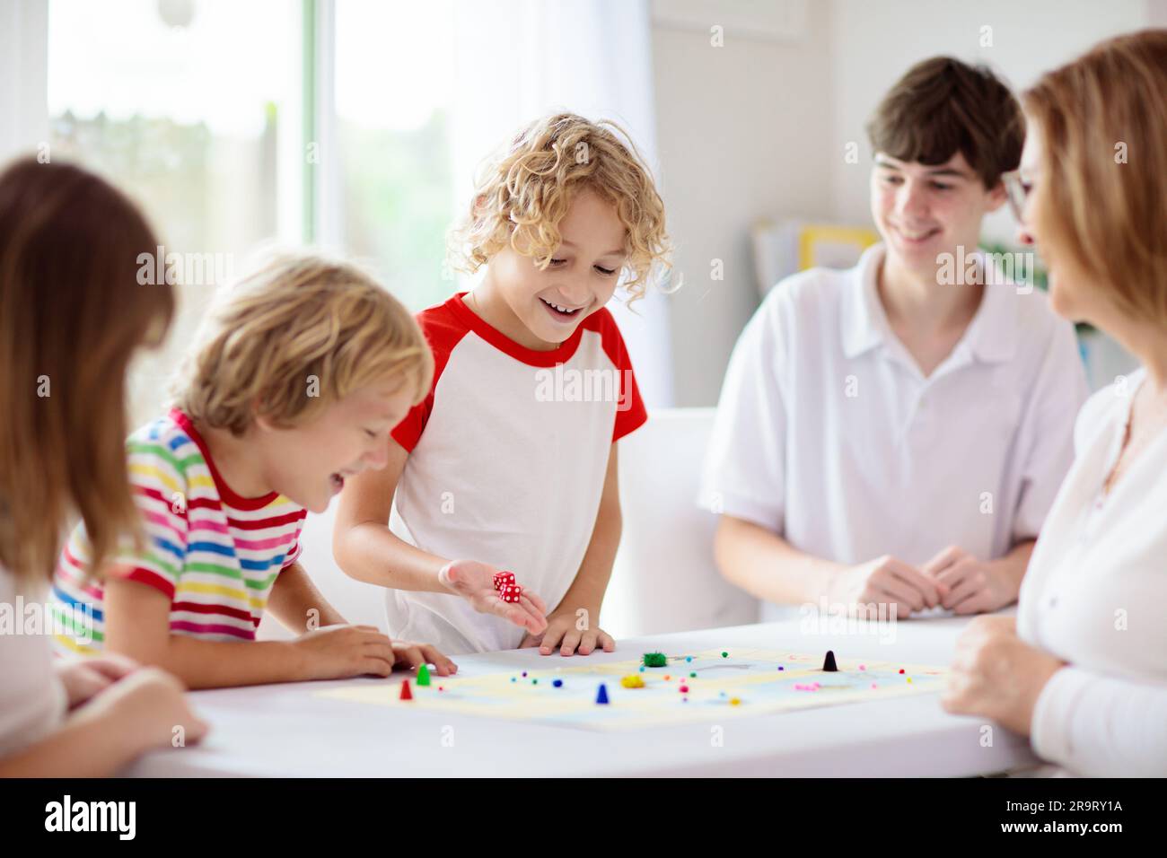 Family playing board game at home. Kids play strategic game. Little boy