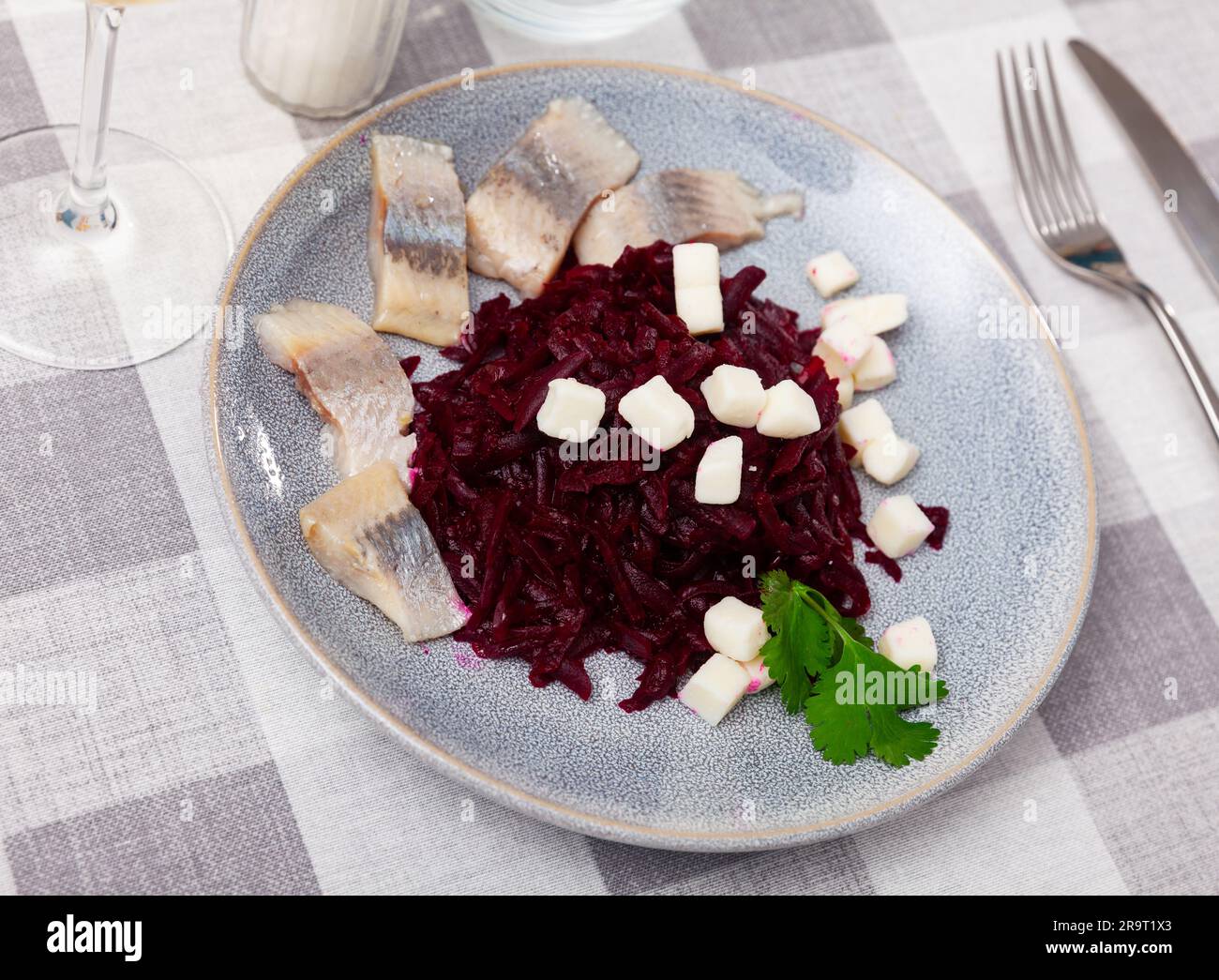 Sliced herring with grated beetroot and cheese served on table Stock Photo