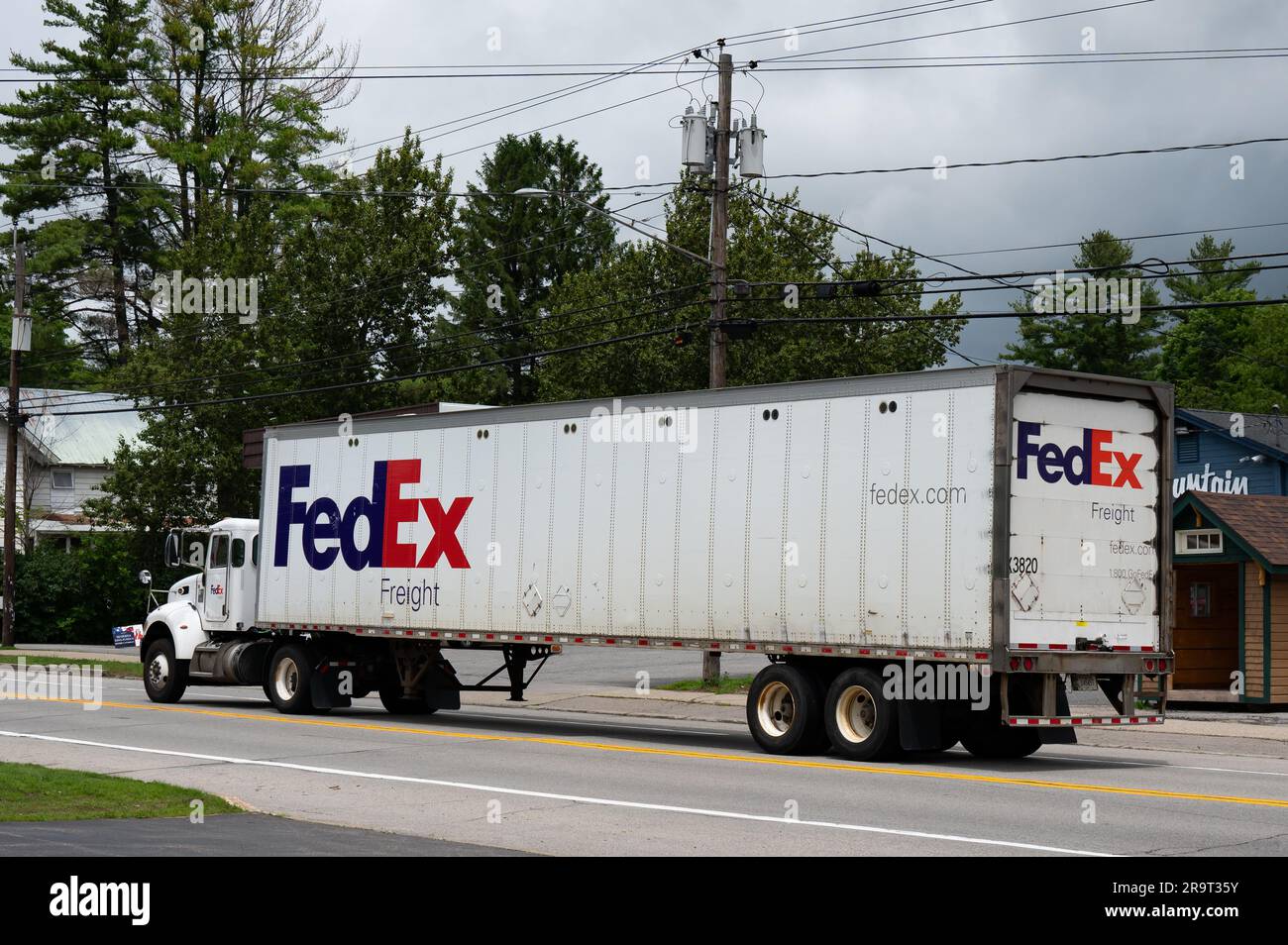 A white FedEx freight tractor trailer truck driving through Speculator, NY Stock Photo