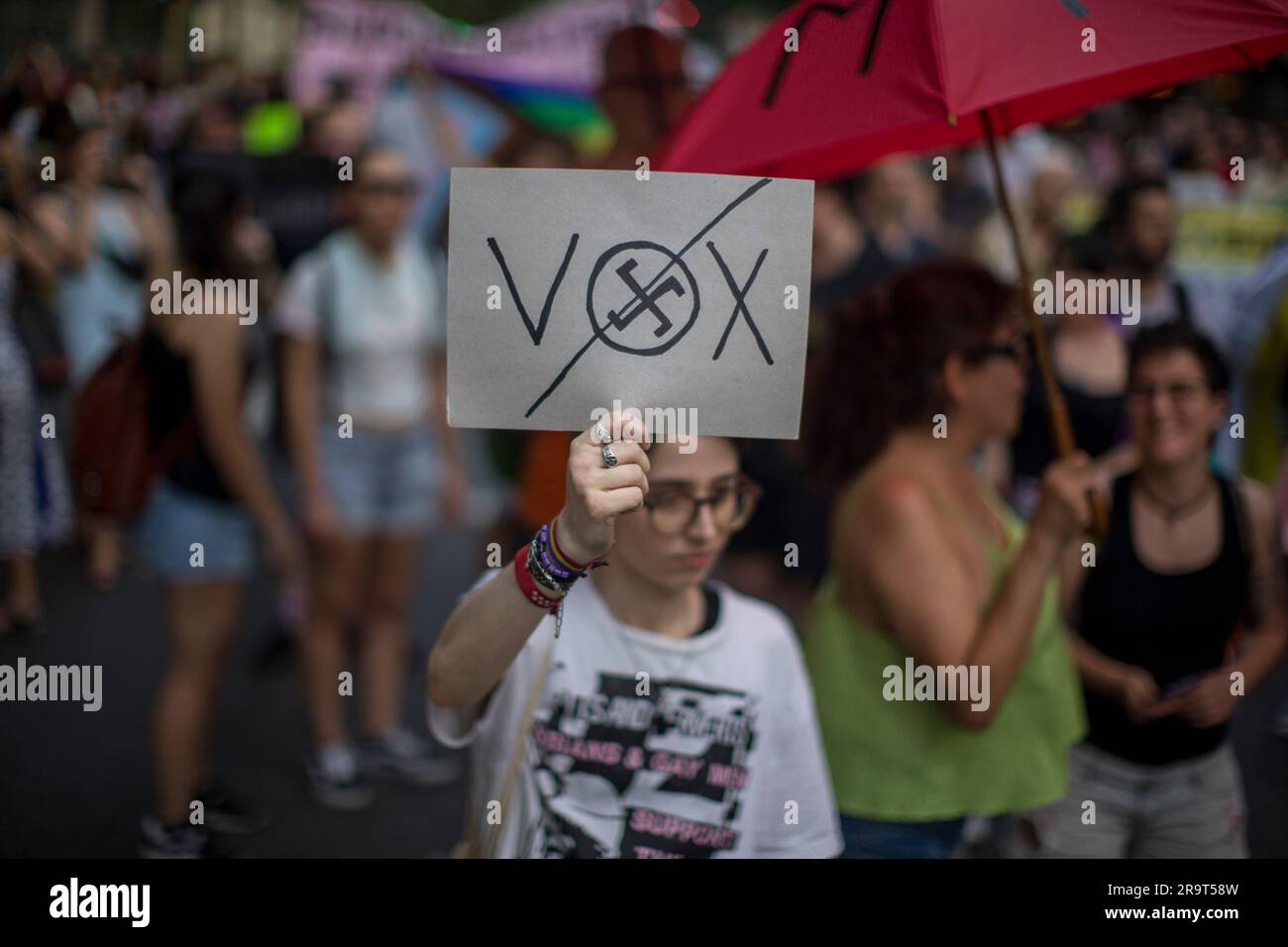 Madrid, Spain. 28th June, 2023. A woman holds a placard with the acronym of  the Spanish ultra-right political party VOX during the Critical Pride March  through the streets of Madrid. Different groups