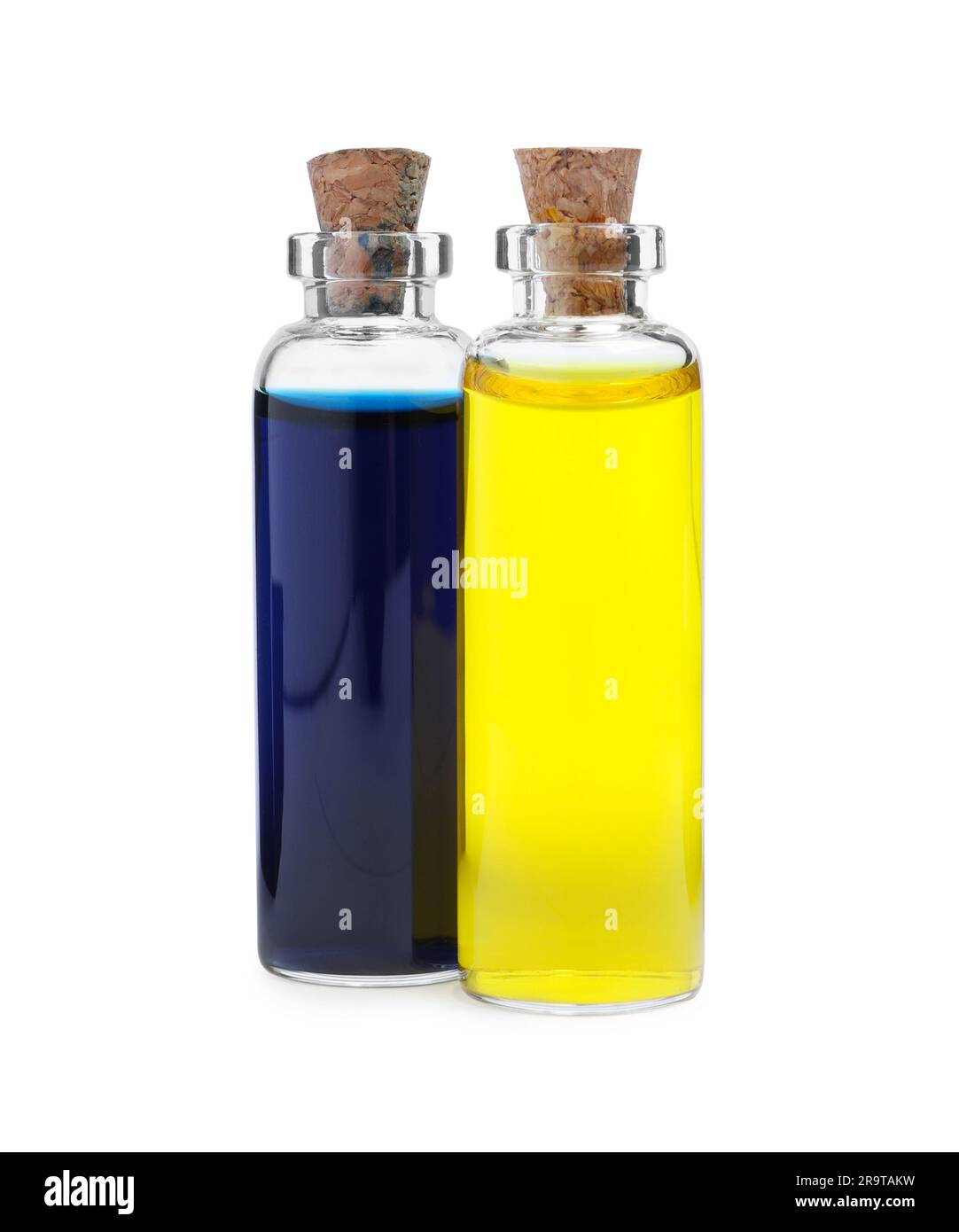 Glass bottles with different food coloring on white background Stock