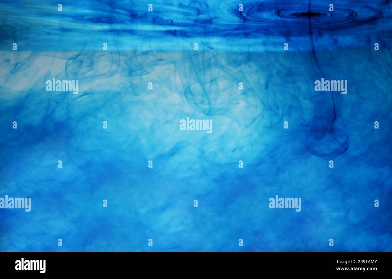 Liquid with bright blue paint as background Stock Photo - Alamy