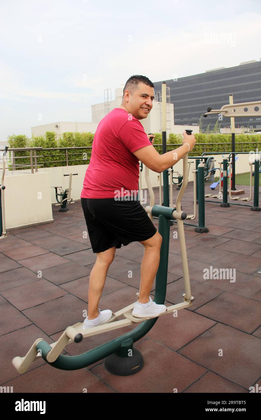 Darkhaired 40yearold Latino man exercises on the roof garden of his