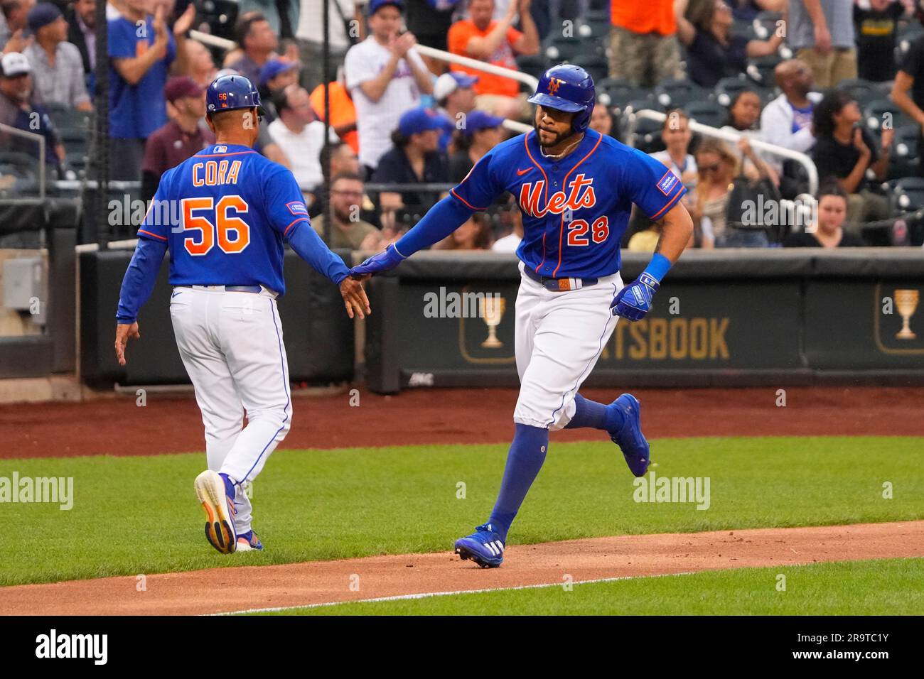 FLUSHING, NY - JUNE 28: New York Mets Third Base Coach Joey Cora (56)  congratulates New York Mets Left Fielder 5Tommy Pham (28) for hitting a  home run during the second inning