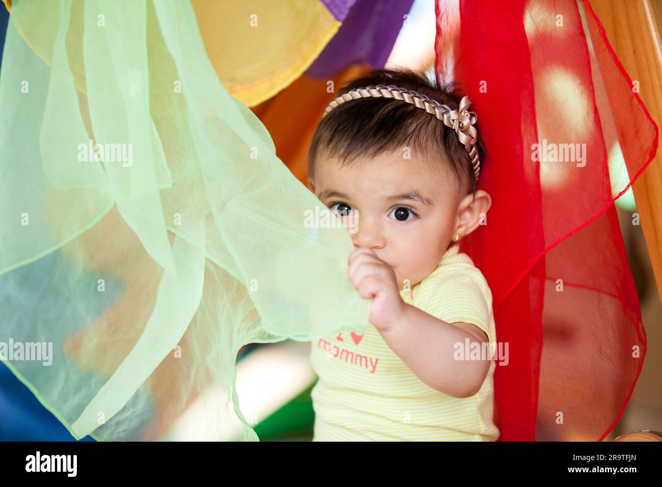 Beautiful ten months baby girl playing with colorful fabrics. Early ...