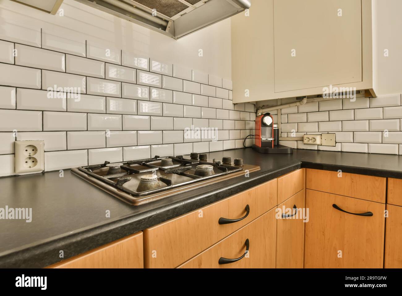 a kitchen with black counter tops and white subway tiles on the wall