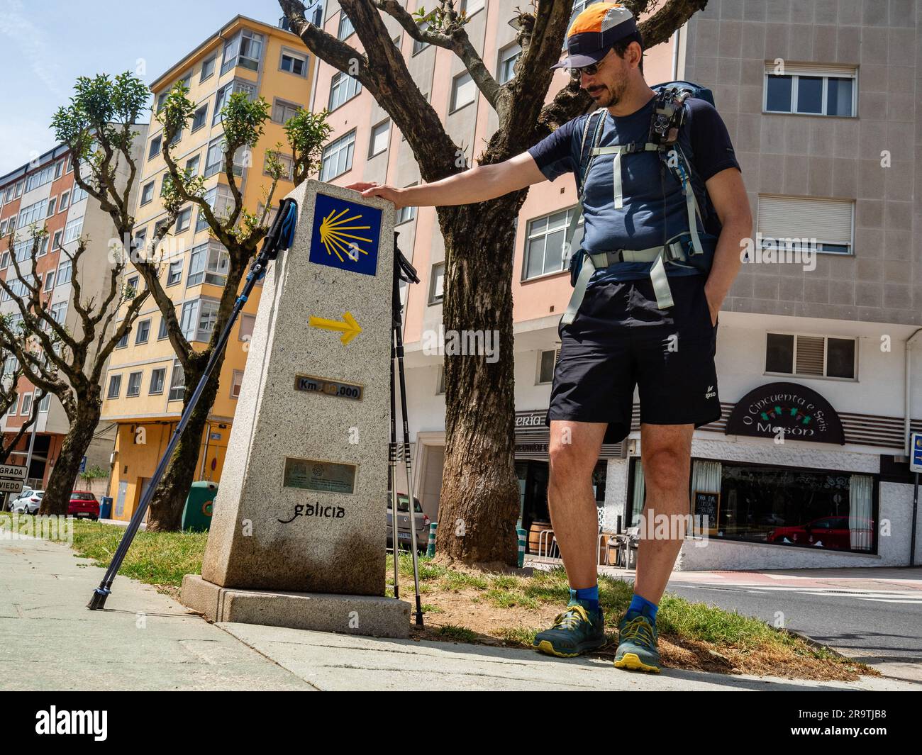 May 29, 2023, Lugo, Spain: A pilgrim is seen posing next to the stone marker that is pointing at the one-hundred kilometer. The Camino de Santiago (the Way of St. James) is a large network of ancient pilgrim routes stretching across Europe and coming together at the tomb of St. James (Santiago in Spanish) in Santiago de Compostela in northwest Spain. The Camino Primitivo is the original and oldest pilgrimage route. It links Oviedo with Santiago de Compostela. It's characterized as being one of the hard routes but also for being one of the most attractive Jacobean routes. In 2015, it was listed Stock Photo