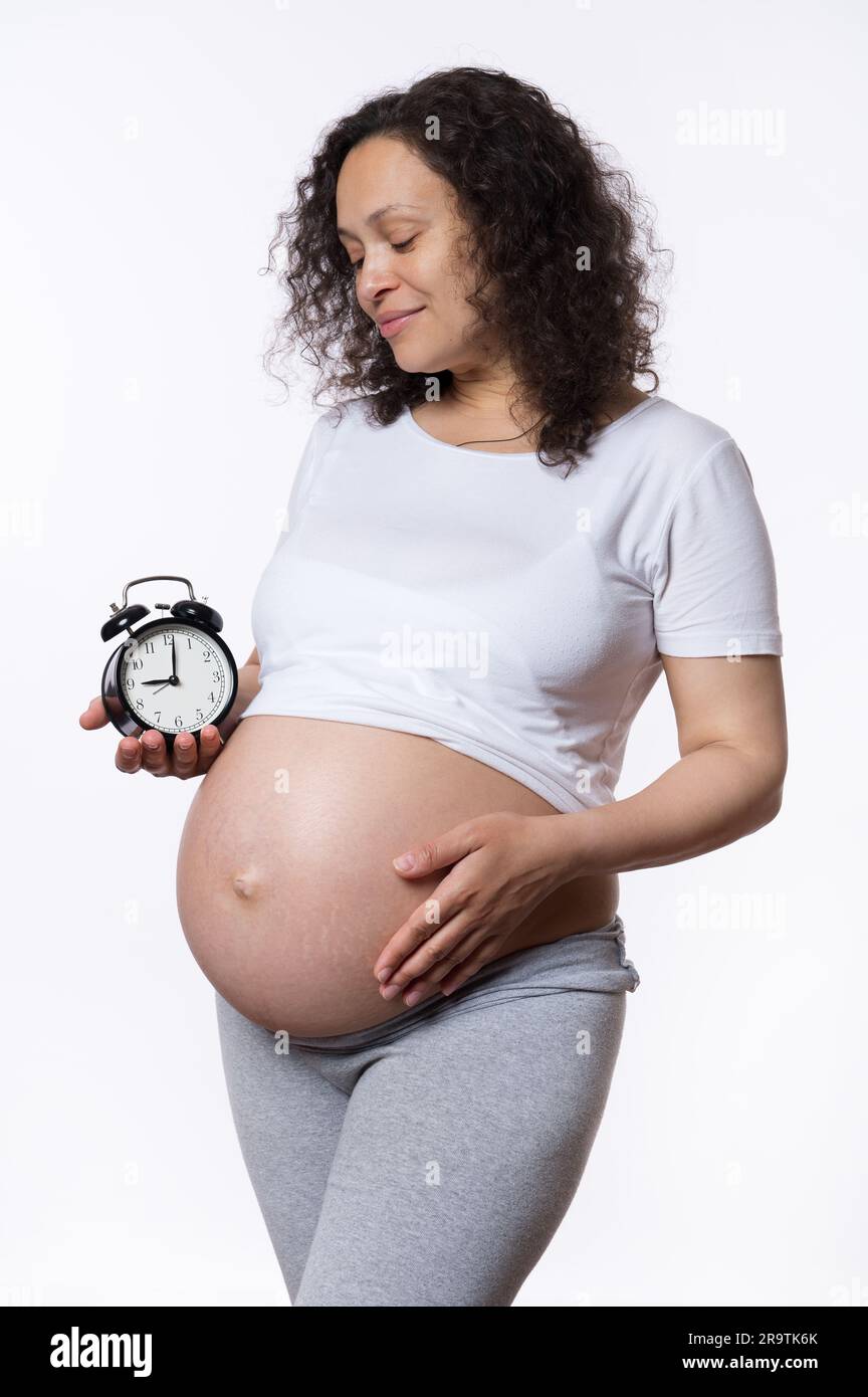 Beautiful pregnant woman, expectant mother smiling, caressing her belly,  enjoying happy moments of carefree pregnancy Stock Photo - Alamy