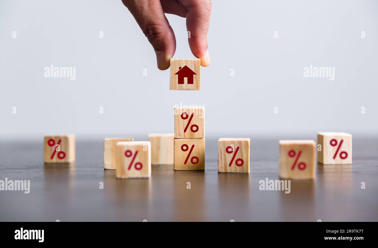 Hand building a house by wooden cubes with the percentage sign on them. Concept of Interest rate financial mortgage rates, home loans, home refinance, Stock Photo