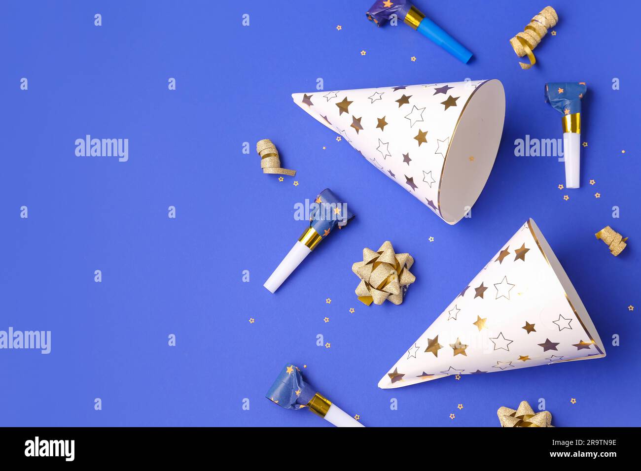 Party hats and whistles on dark blue background Stock Photo - Alamy