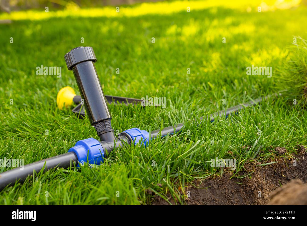 Installing a popup sprinkler in the lawn, closeup. Grass Irrigation Integration Stock Photo
