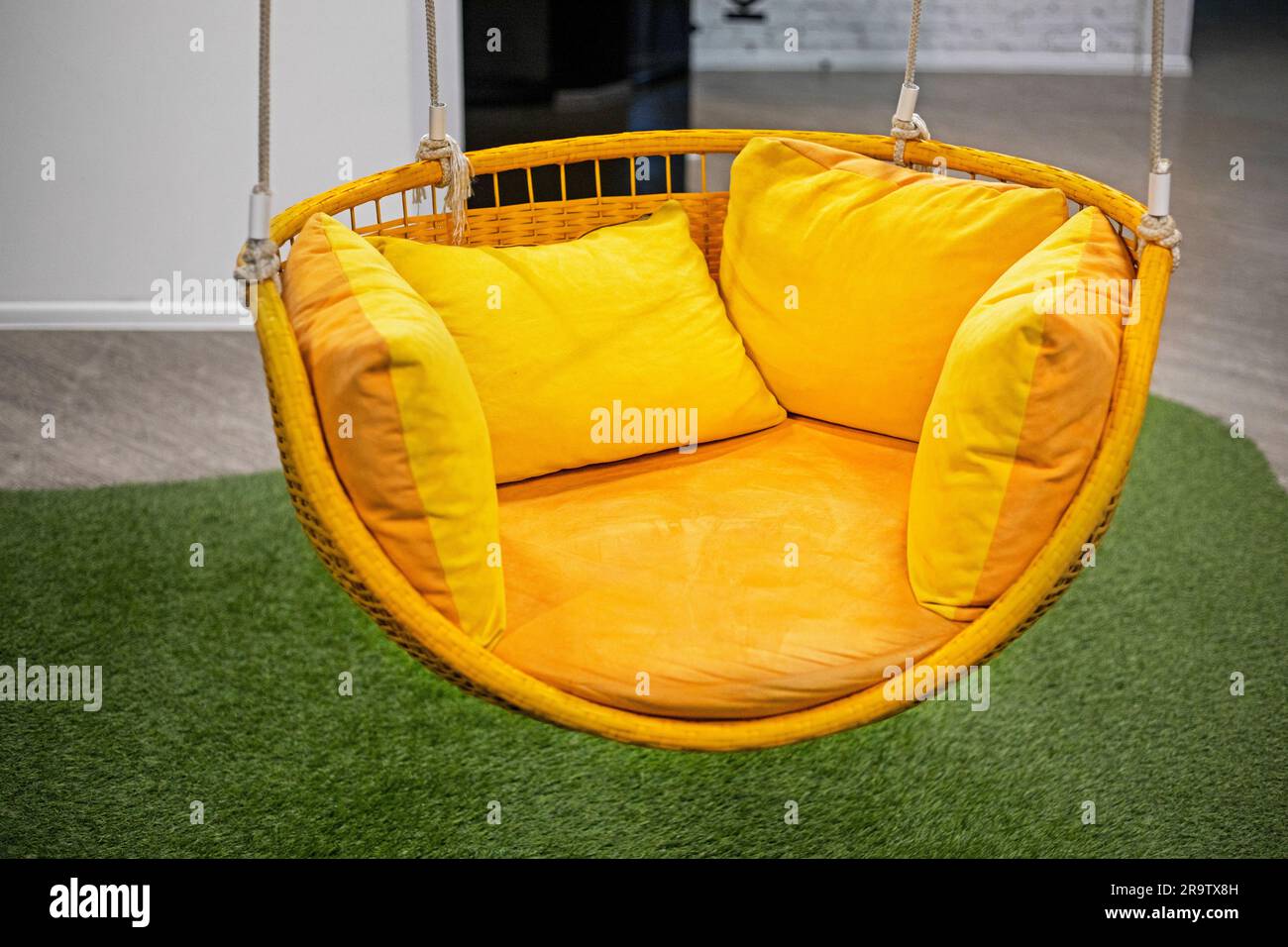 yellow hanging swing chair in the office for relaxing. Modern