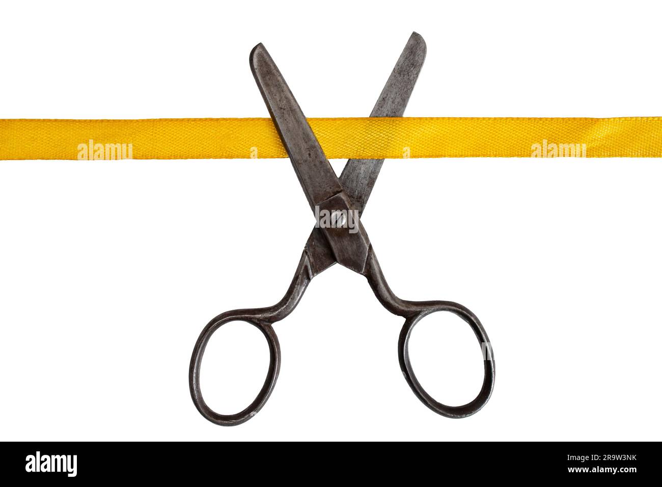 Vintage steel scissors cutting a golden satin ribbon, close up isolated on white Stock Photo