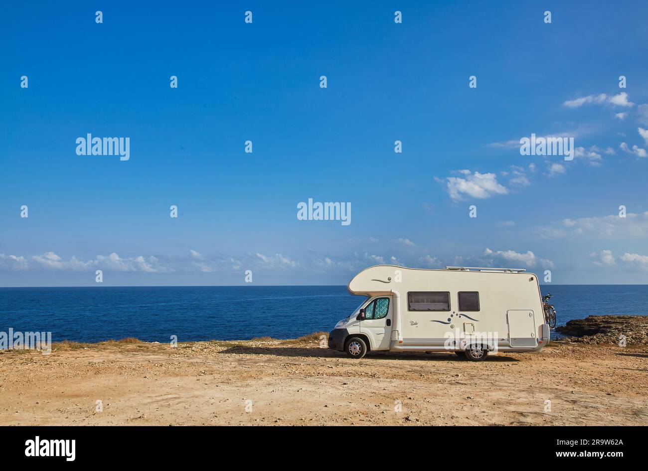 Camper rv caravan on mediterranean coast in Italy. Wild camping on sea shore. Holidays and travel in motor home. Stock Photo