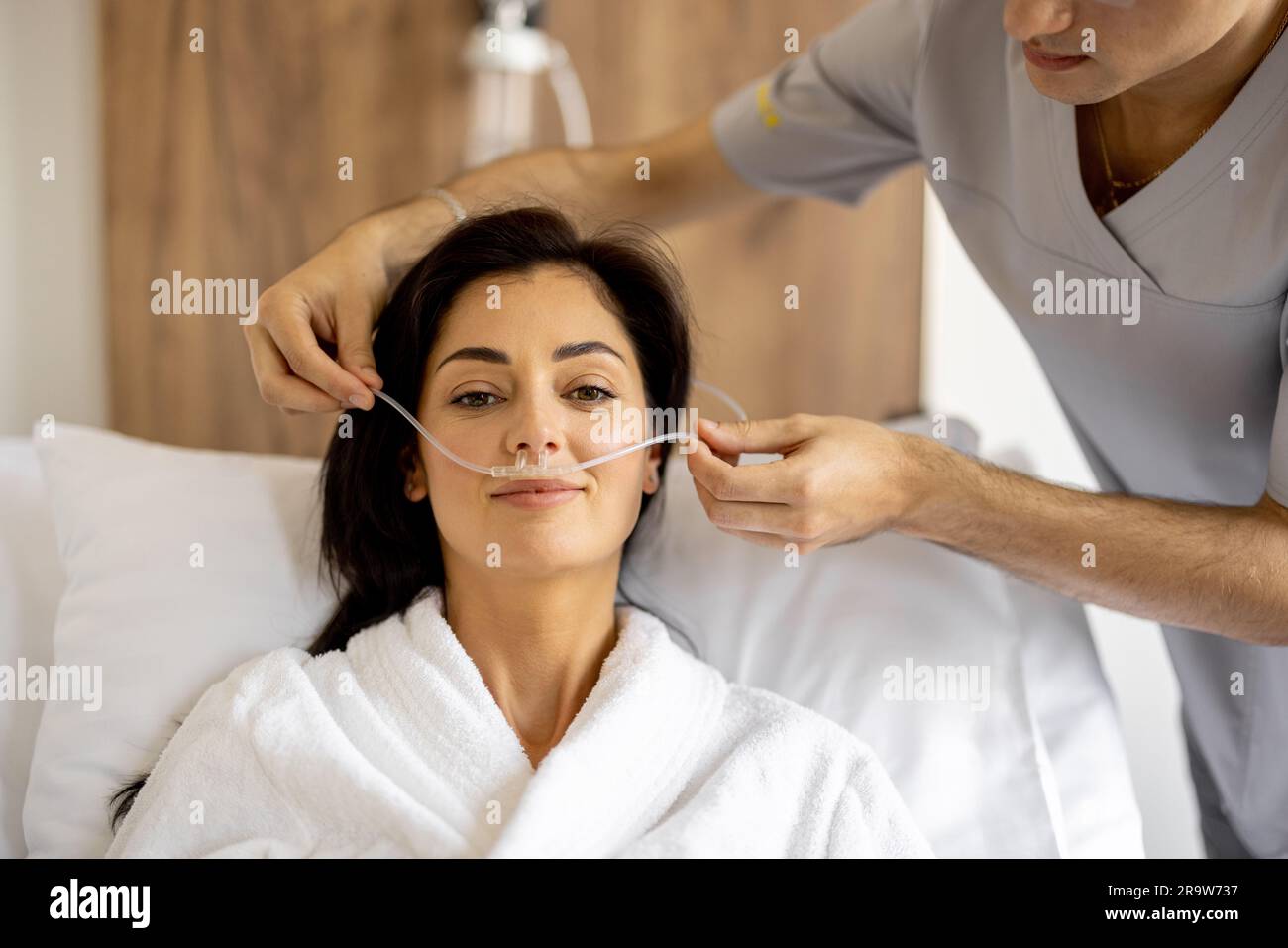 Nurse wearing oxygen mask for a patient Stock Photo - Alamy