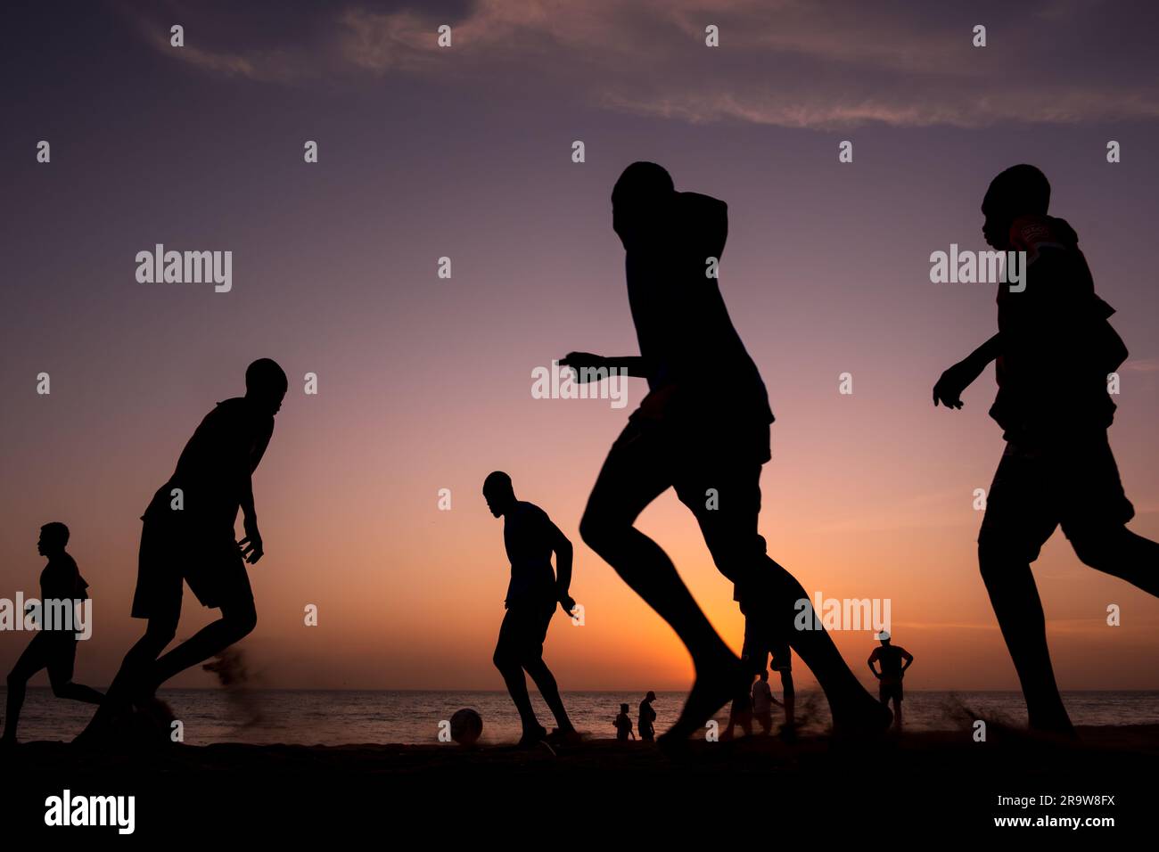 Football players at sunset on a beach in Dakar, Senegal Stock Photo