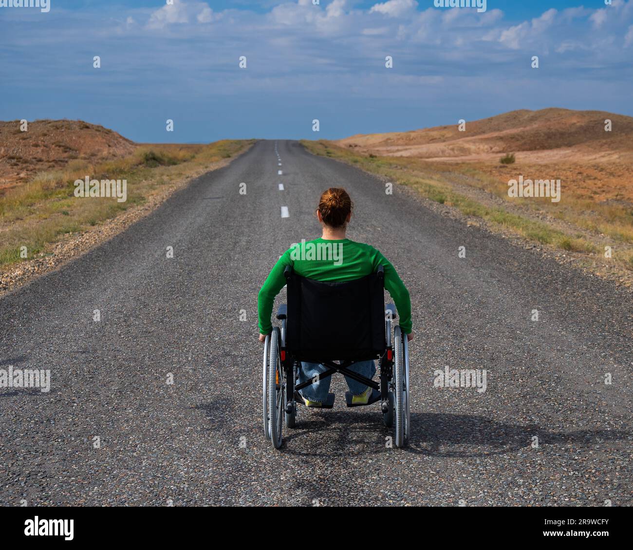 Woman in a wheelchair on a highway in the steppes Stock Photo Alamy