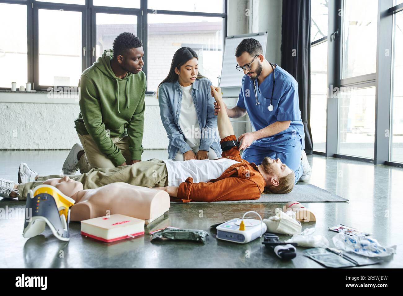 medical instructor applying compression tourniquet on arm of seminar