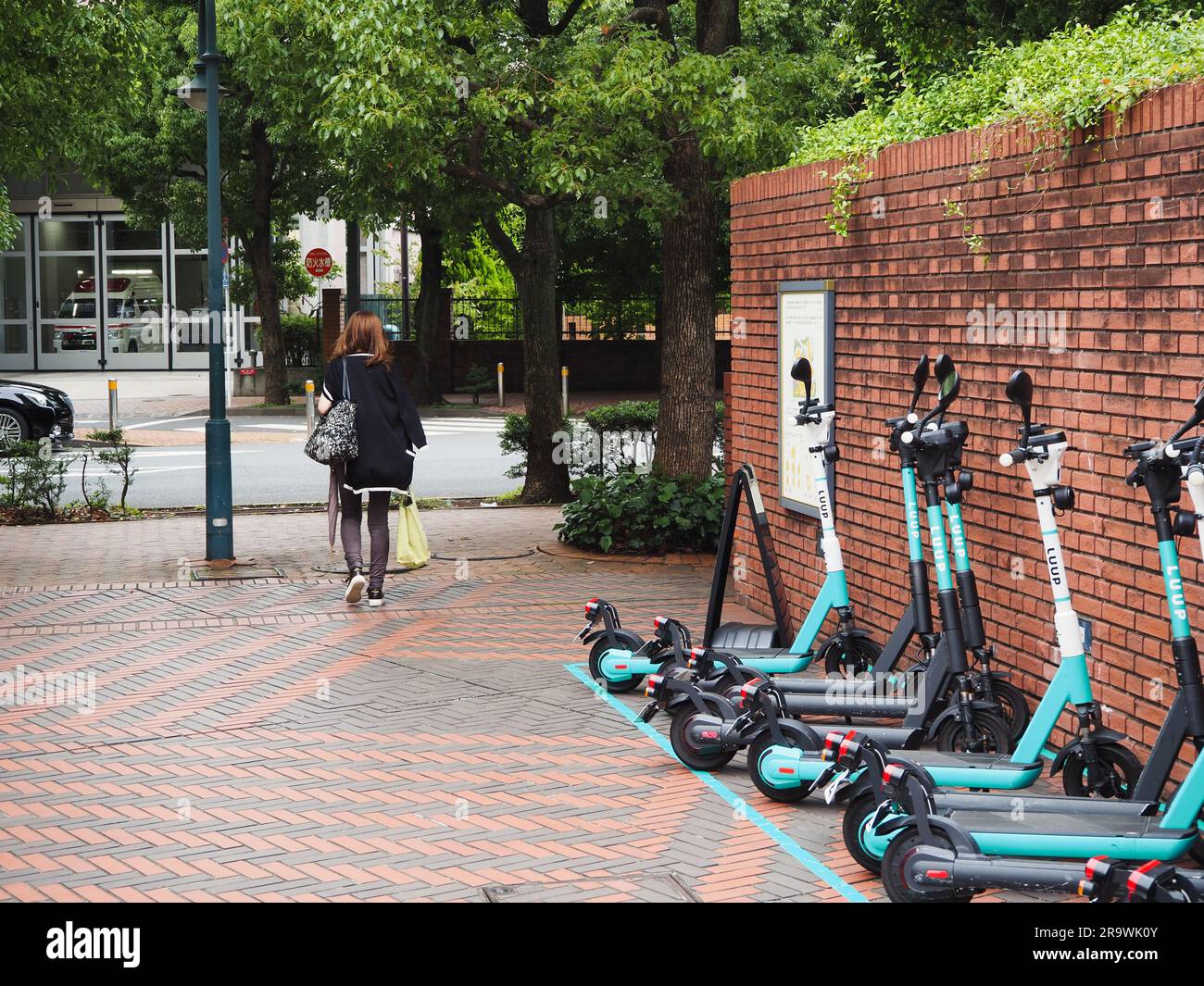TOKYO, JAPAN - June 14, 2023: A row of Luup rental e-scooters in Yebisu Garden Place in Ebisu. Stock Photo