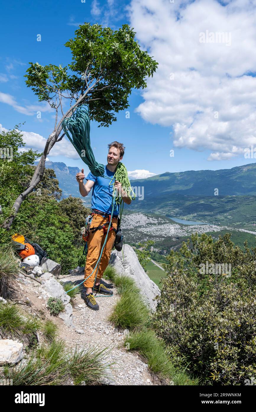 Climber throws climbing rope over his shoulder, multipitch climbing