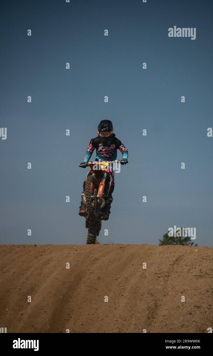 A man in racing suit riding a motorcycle on a dirt track Stock Photo ...