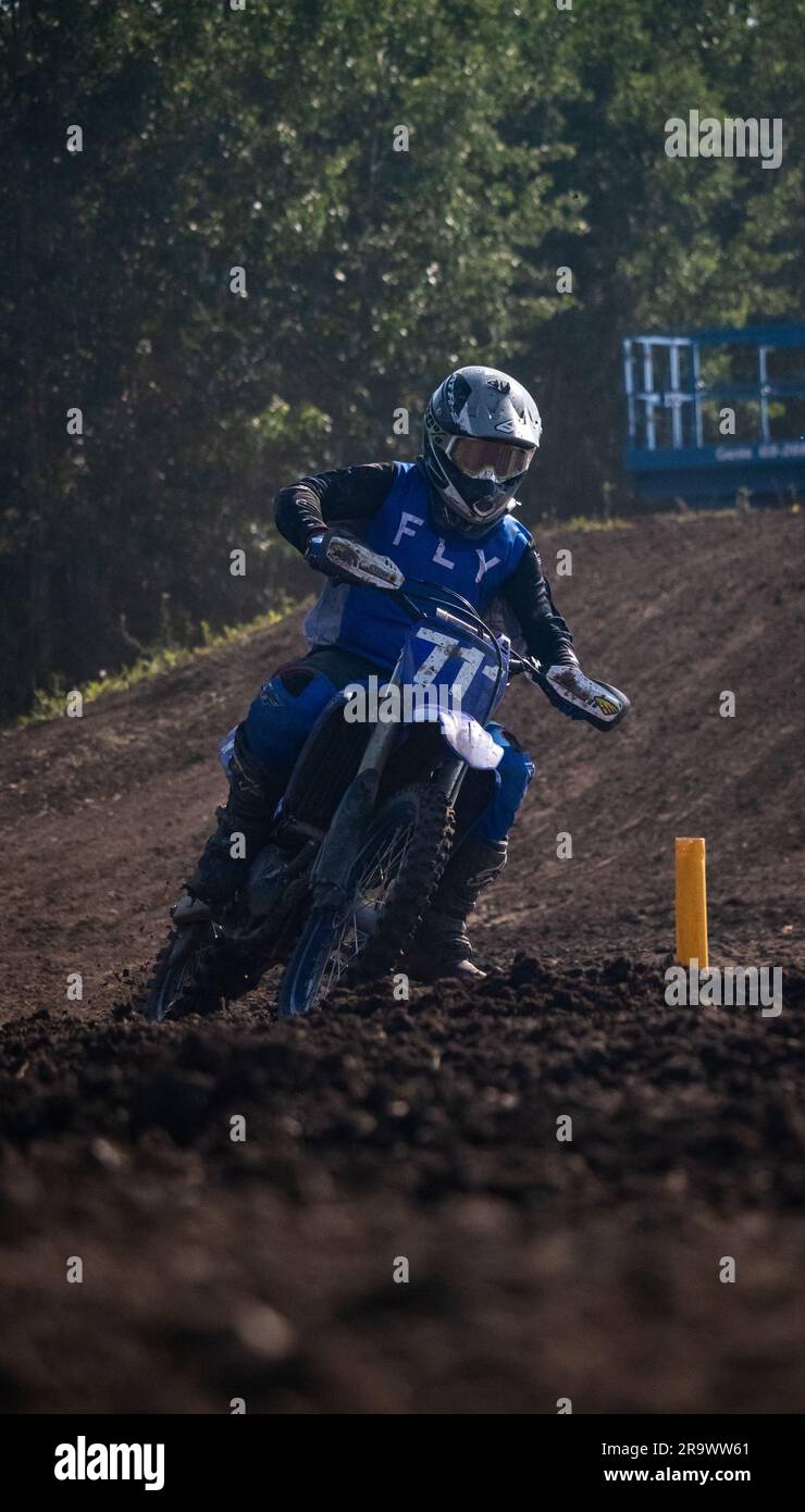 A man in racing suit riding a motorcycle on a dirt track Stock Photo ...