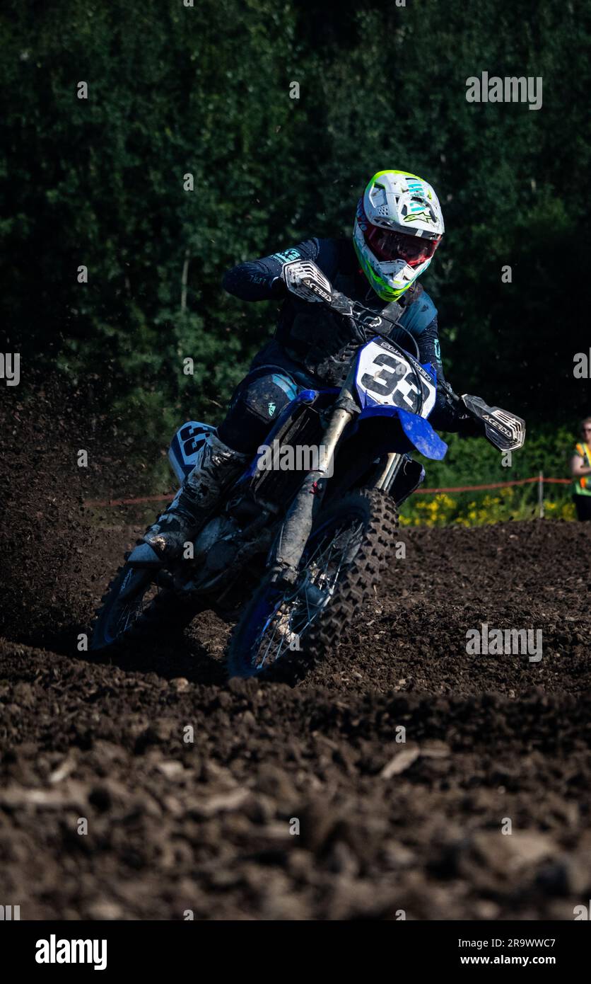 A man in racing suit riding a motorcycle on a dirt track Stock Photo ...