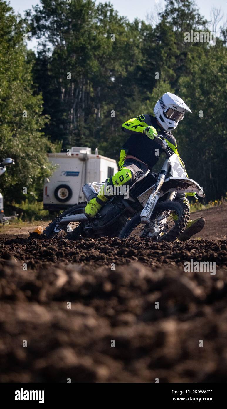 A man in racing suit riding a motorcycle on a dirt track Stock Photo ...