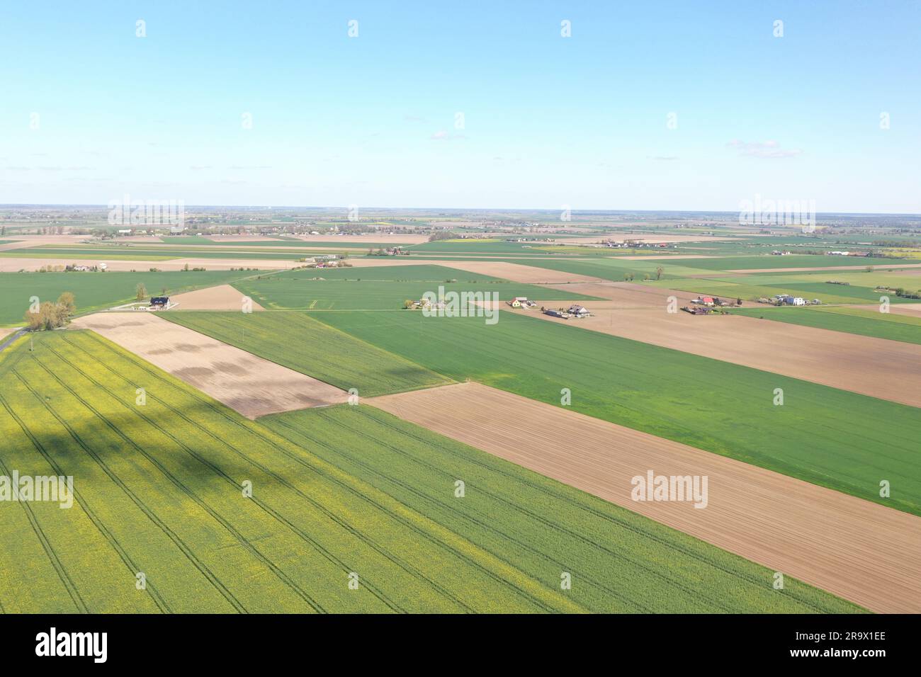 An aerial view of a rural landscape with cultivated fields, crop lines ...