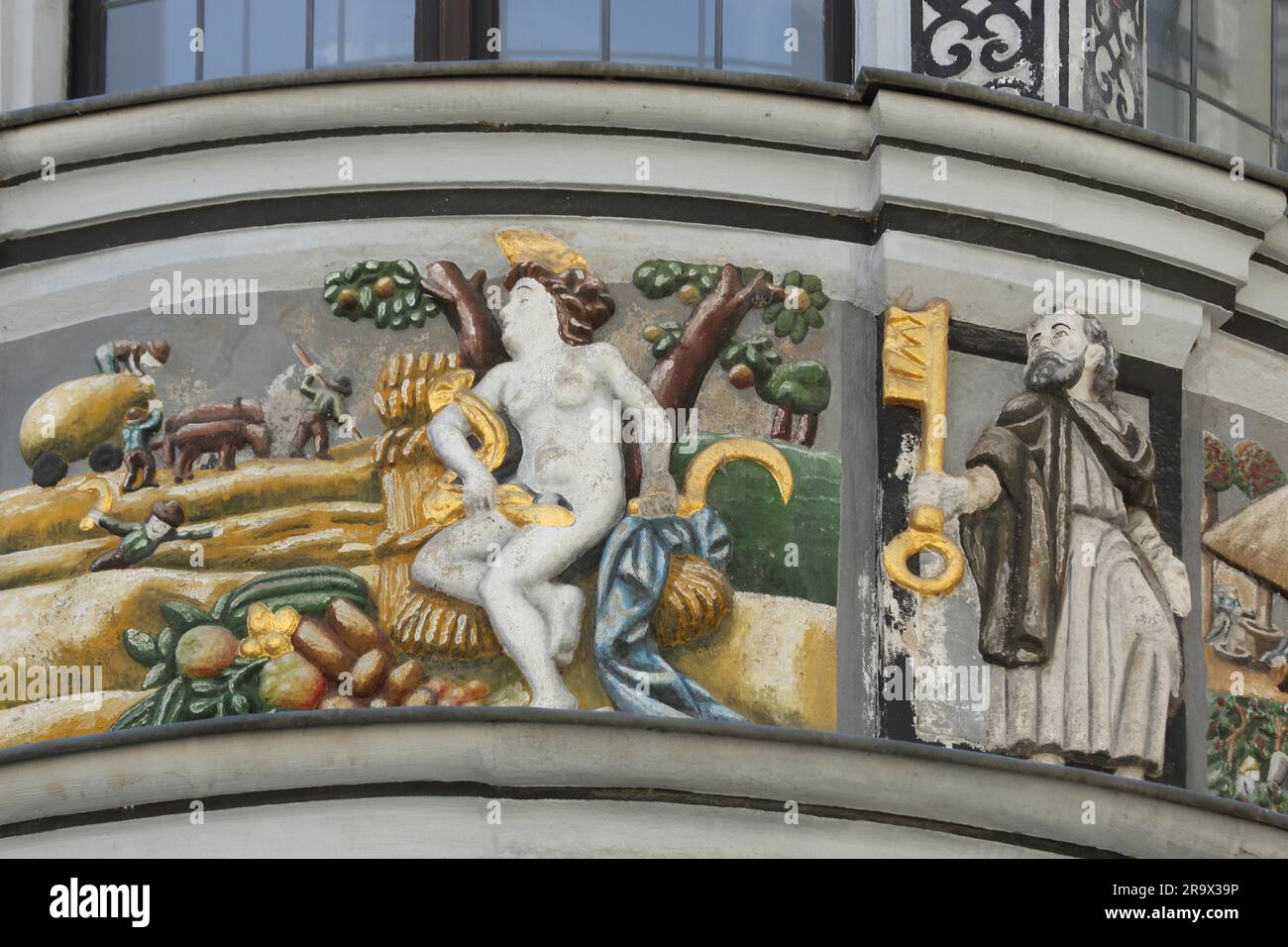 Painting and relief on the oriel of the pharmacy, Peter with golden key and woman with sickle, market place, Gera, Thuringia, Germany Stock Photo