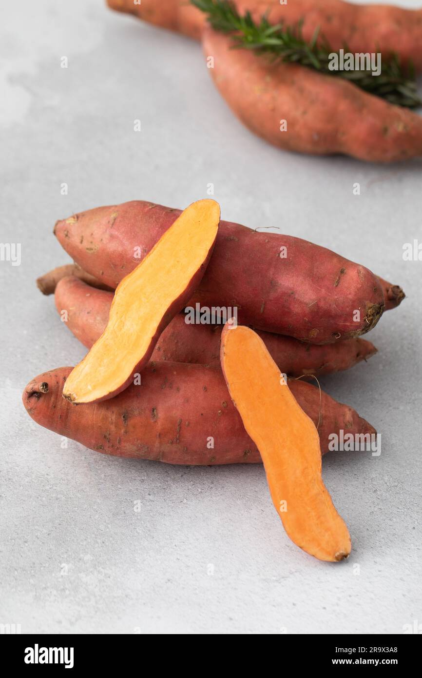 Raw sweet potatoes whole and cut. Orange kumara, sweet potato