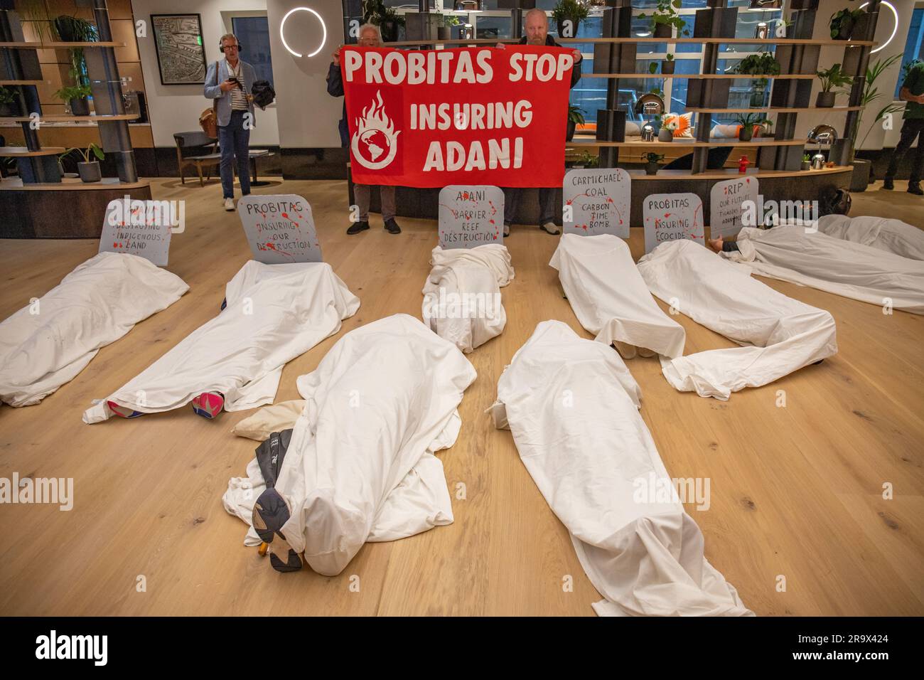 London, England, UK 29 June 2023 A coalition of protesters including Tipping Point Group, Coal Action Network, Stop Adani Group, South Asian Solidarity Network and Extinction Rebellion, hold a die-in at the new offices of Probitas in opposition to their involvement with Adani and the Carmichael coal mine in Australia. The die-in was attended by police but no arrests were made and the protesters left peacefully at 9am. Stock Photo