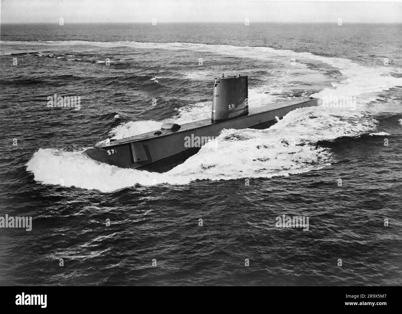 Nuclear submarine out in the ocean, either surfacing or starting a dive Stock Photo