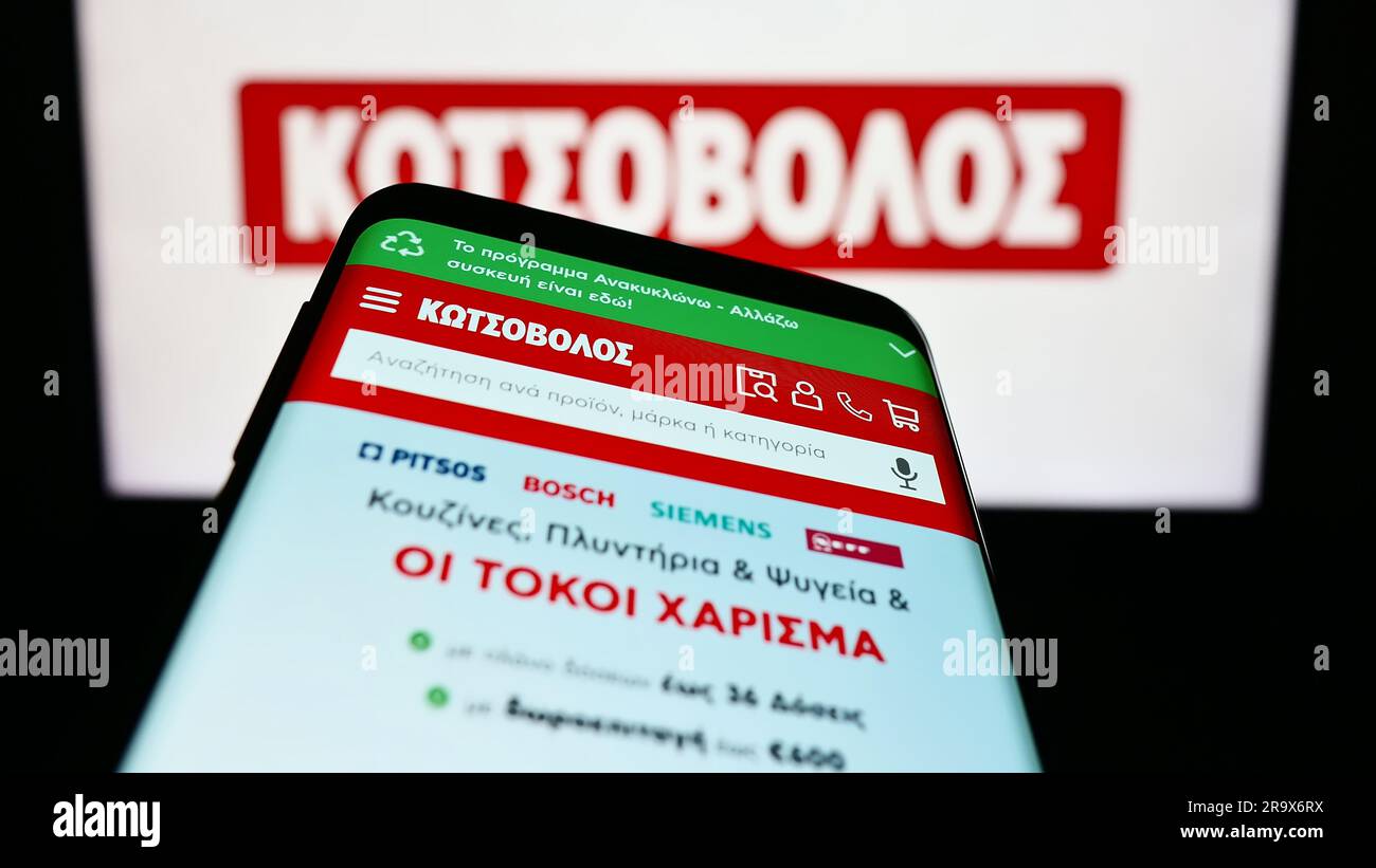 Smartphone with website of Greek electronics retail company Kotsovolos on screen in front of business logo. Focus on top-left of phone display. Stock Photo