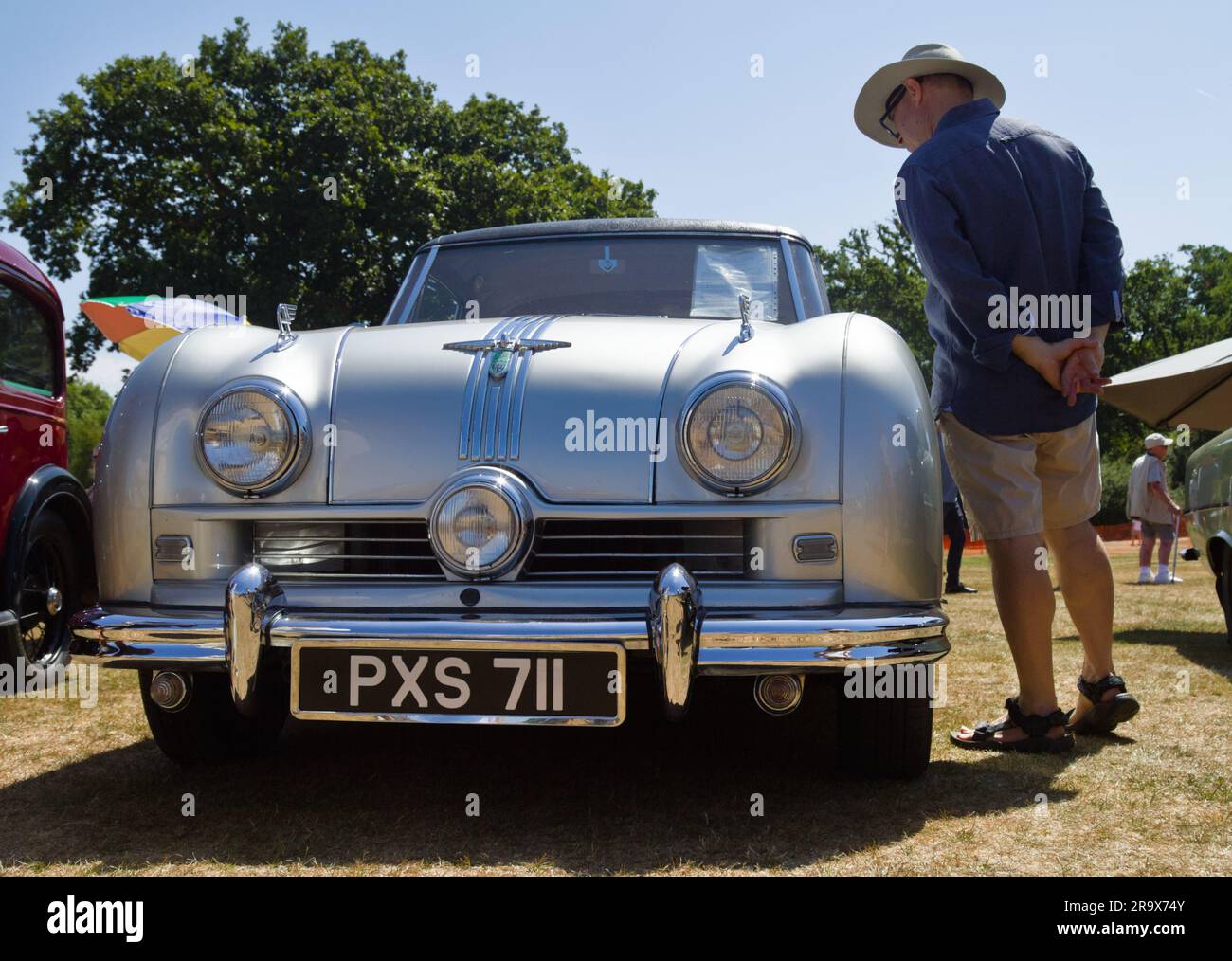 Man Looking At A Rare Retro 1950 Austin Atlantic A90 Retro Motor vehicle in Metallic Grey, England UK Stock Photo
