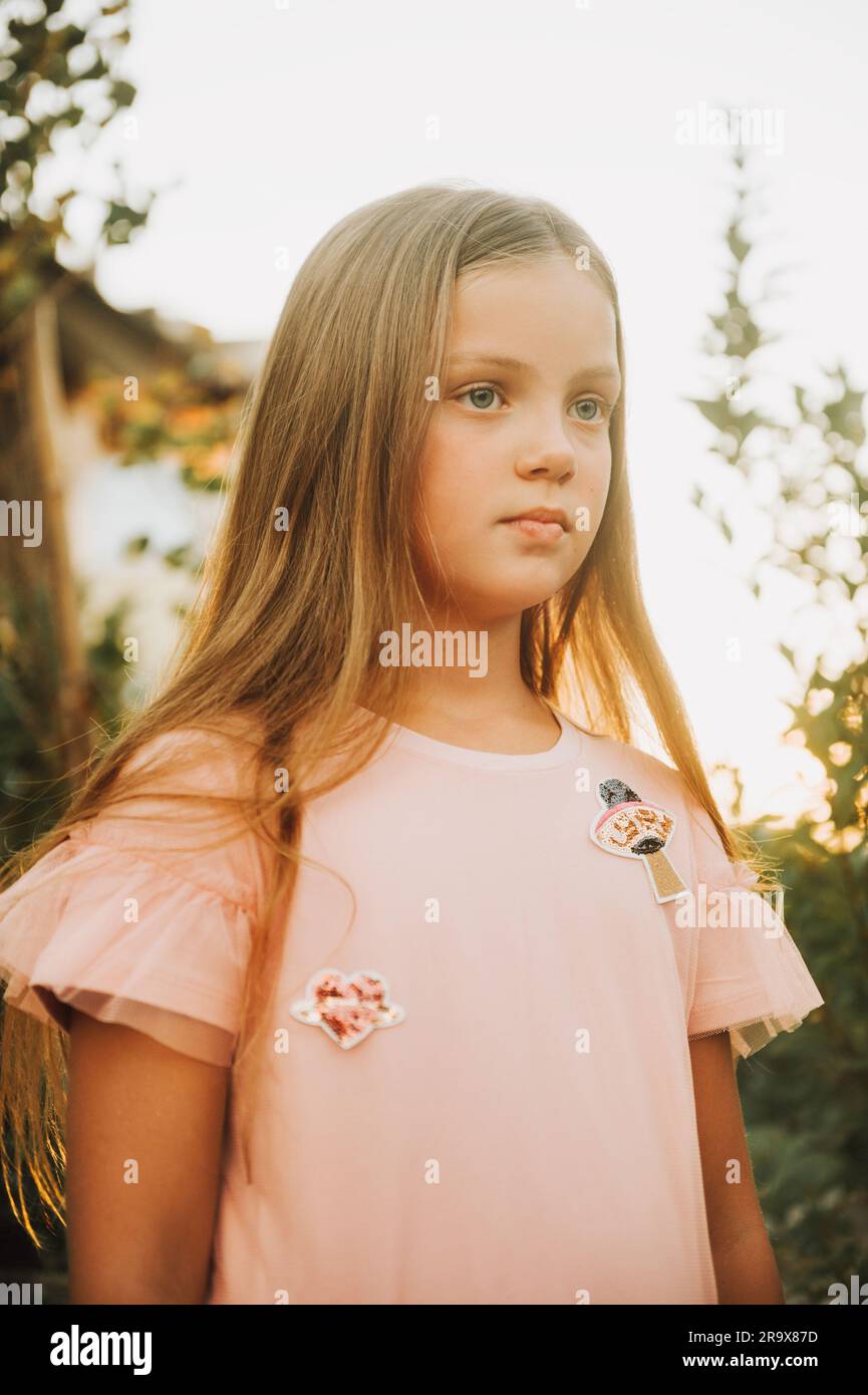Outdoor portrait of beautiful little girl with long blonde hair wearing ...