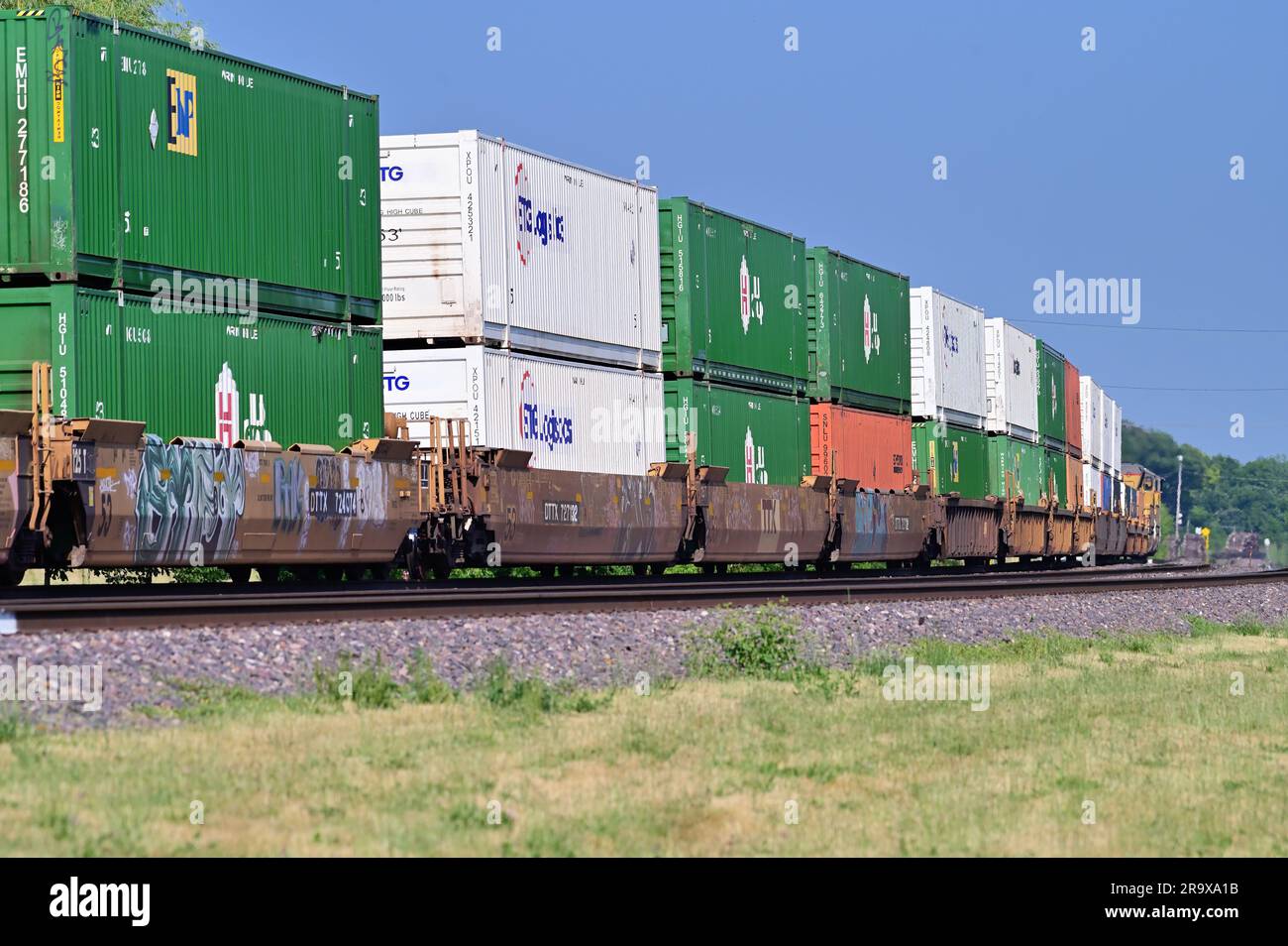 West Chicago, Illinois, USA. Two locomotives lead an Union Pacific intermodal freight train into a curve in northeastern Illinois. Stock Photo