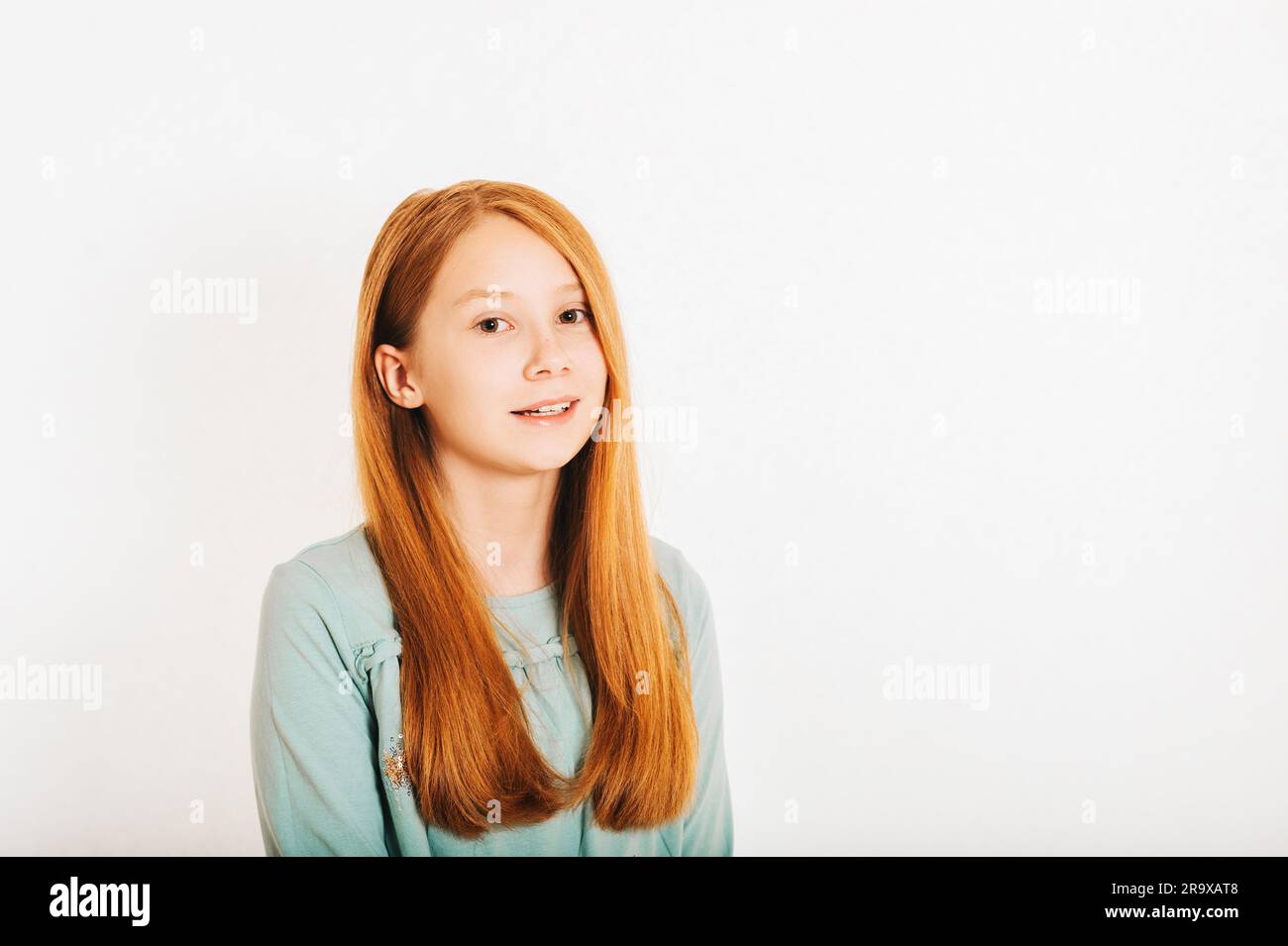 Studio shot of young preteen red-haired girl against white background Stock Photo