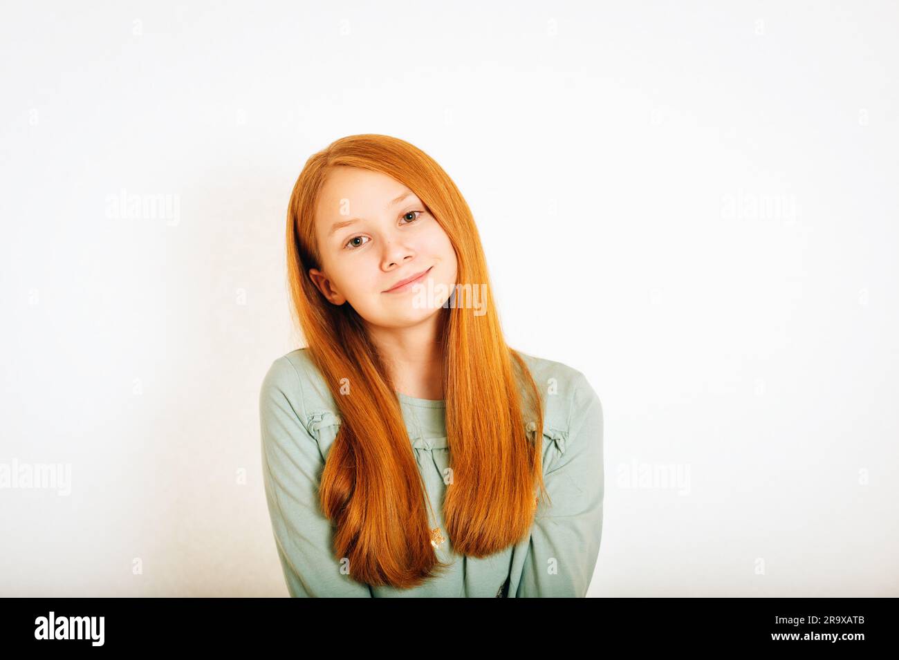 Studio shot of young preteen red-haired girl against white background Stock Photo