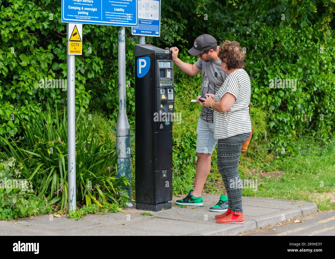 People paying for parking in a car park at a pay and display ticket