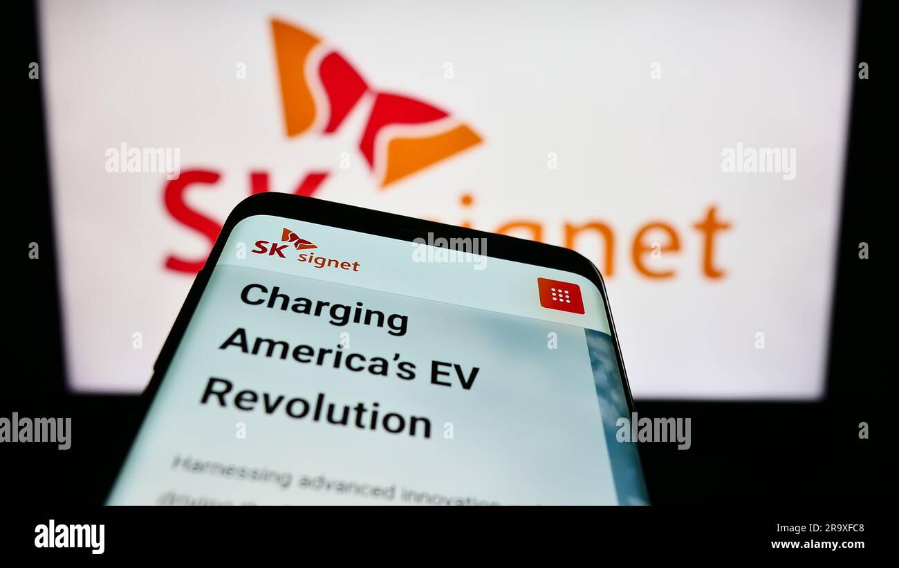 Smartphone with website of Korean EV charging company SK Signet on screen in front of business logo. Focus on top-left of phone display. Stock Photo